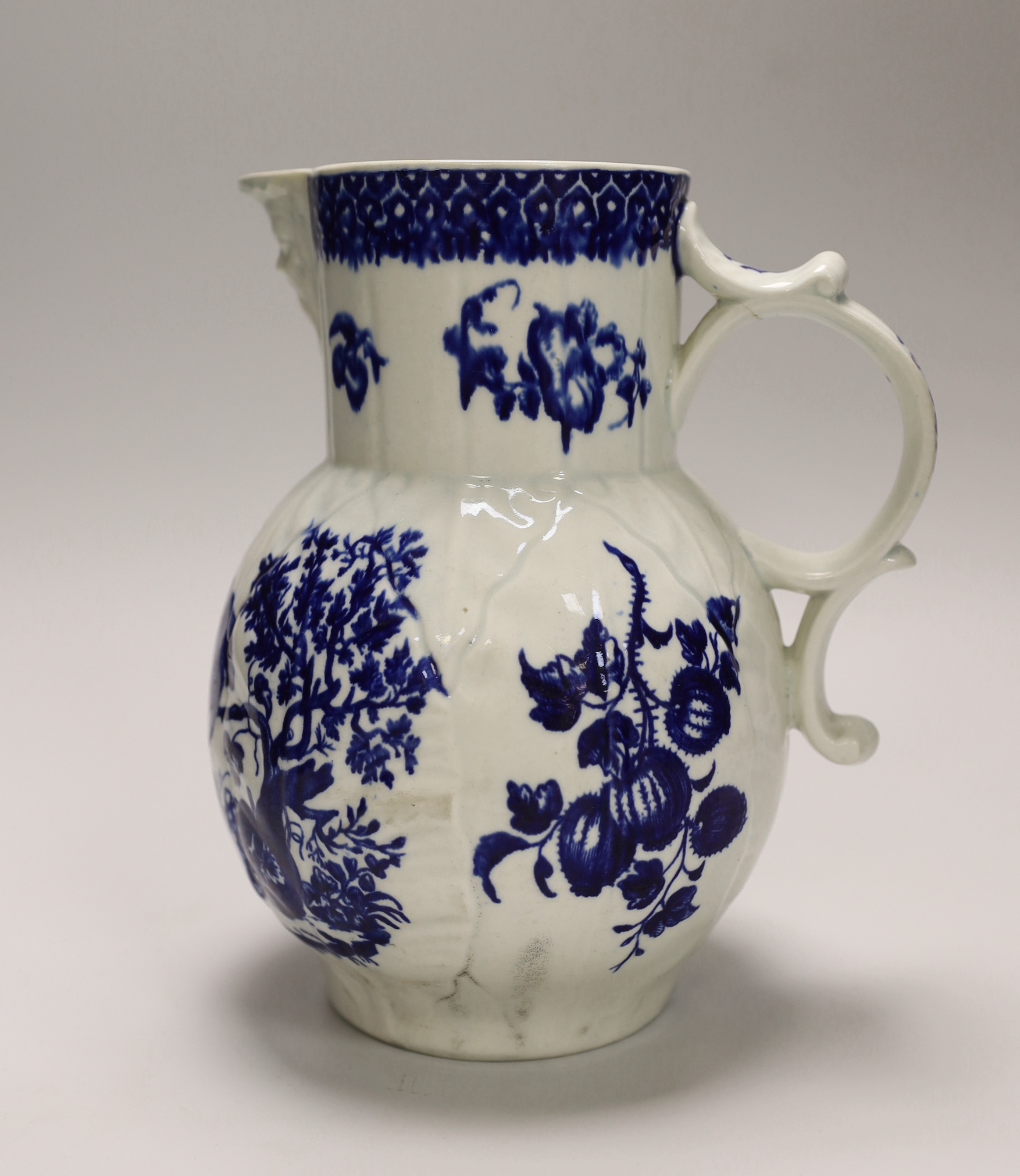 An 18th century Worcester fine mask jug decorated with the Parrot Pecking Fruit pattern, disguised numeral mark, 21cms high
